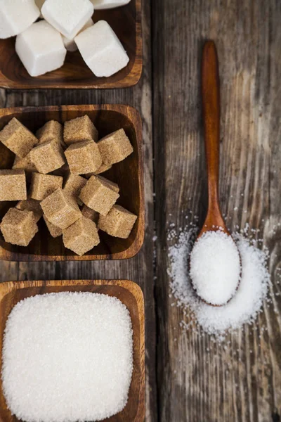 Sugar in a wooden bowls and a spoon