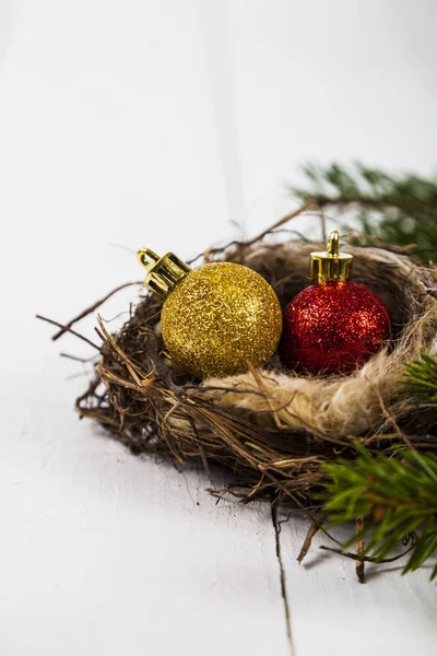 Kerstballen in een nest en Spar takken. — Stockfoto