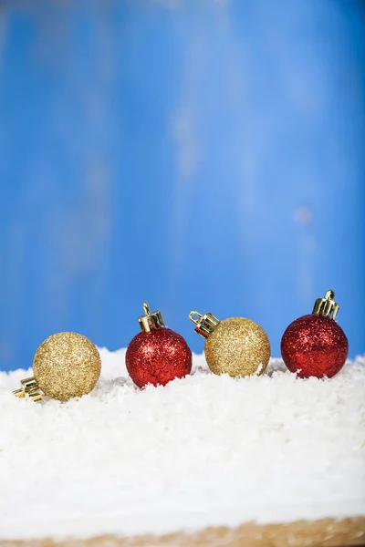 Rote und goldene Weihnachtskugeln auf Schnee — Stockfoto