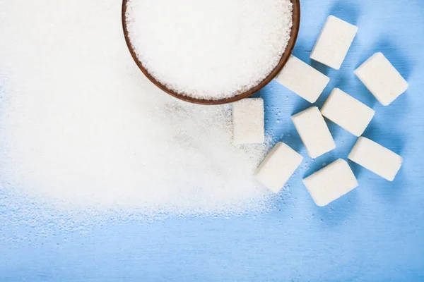 Сахар в деревянной миске и кубики сахара — стоковое фото