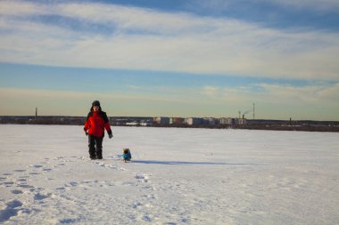 Oğlan ve köpek kış aylarında yürüyen. 