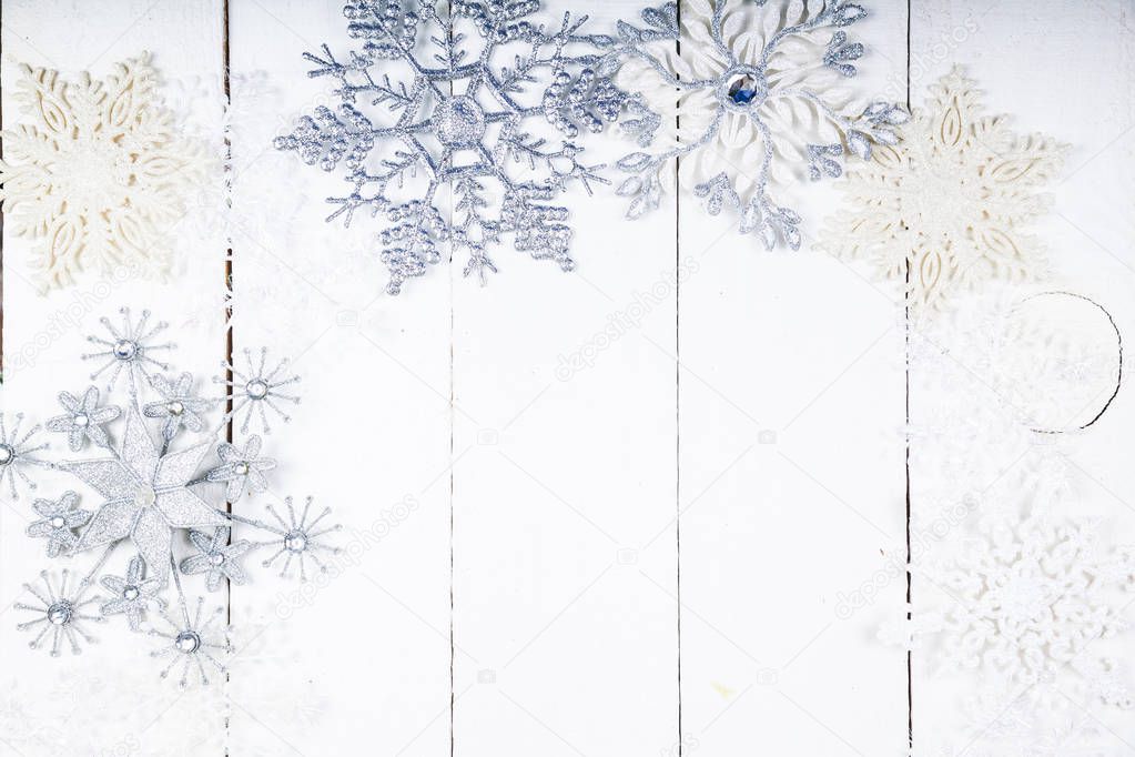 Silvery snowflakes on a wooden background