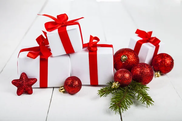 Karácsonyi ajándékok lucfenyő ág és labdák. — Stock Fotó