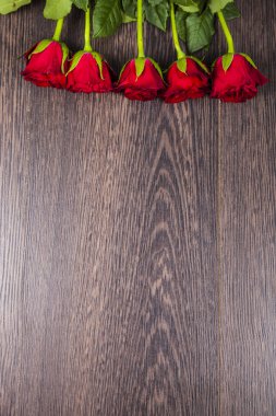 Ahşap arka planda kırmızı güller.