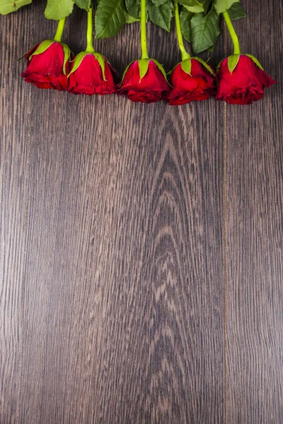 Ahşap arka planda kırmızı güller.