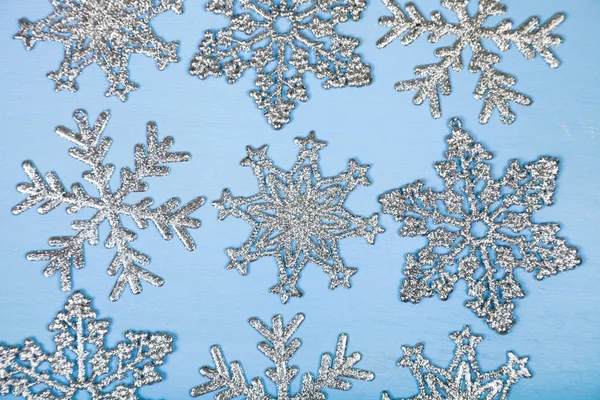 Copos de nieve plateados sobre fondo azul — Foto de Stock