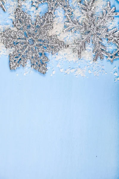 Flocos de neve prateados em um fundo azul — Fotografia de Stock