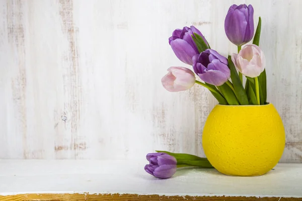 Ramo de tulipanes en un jarrón amarillo — Foto de Stock