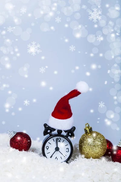 Horloge dans un chapeau de Père Noël et des boules — Photo