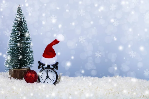 Clock in a Santa hat,ball and a Christmas tree — Stock Photo, Image