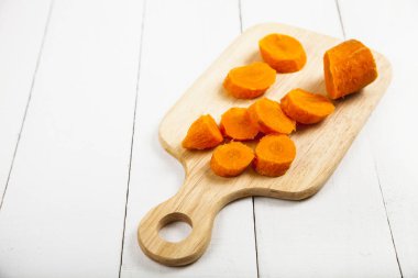 bir kesme tahtası üzerinde havuç dilimlenmiş 