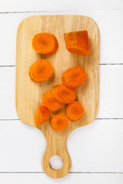 bir kesme tahtası üzerinde havuç dilimlenmiş 