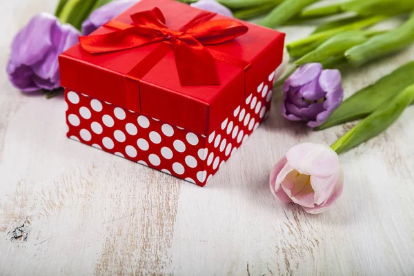 Boeket van tulpen en een gift — Stockfoto