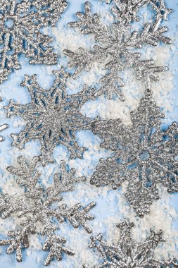 Mavi bir arka plan üzerinde gümüş kar taneleri