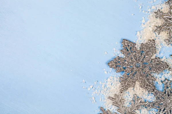 Flocos de neve prateados em um fundo azul — Fotografia de Stock