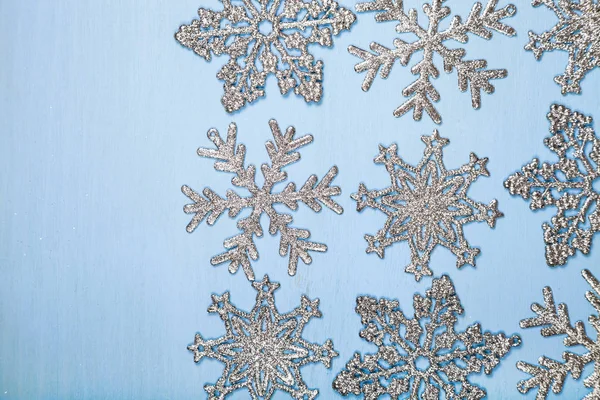 Srebrne płatki śniegu na niebieskim tle — Zdjęcie stockowe