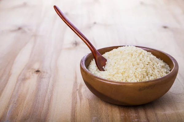 Rauwe rijst in een houten kom — Stockfoto
