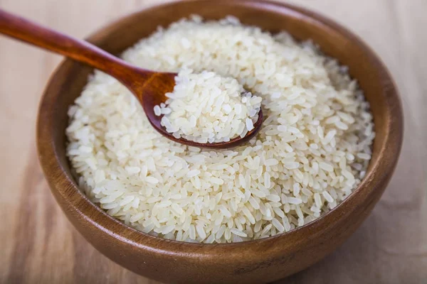 Rauwe rijst in een houten kom — Stockfoto