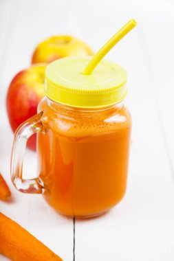 Apple-havuç suyu bir beyaz ahşap tablo.