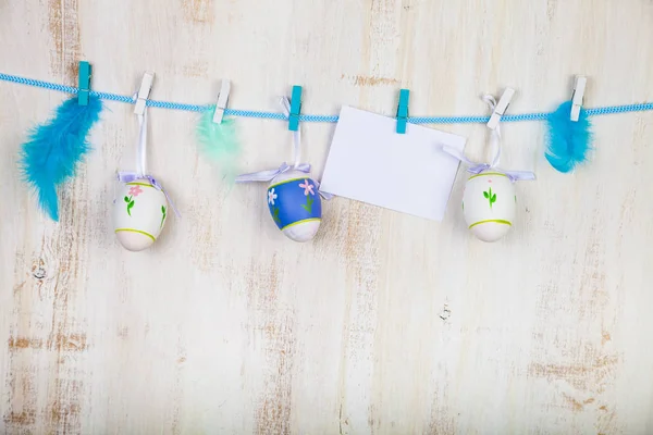 Easter Eggs,feathers and paper on a rope — Stock Photo, Image