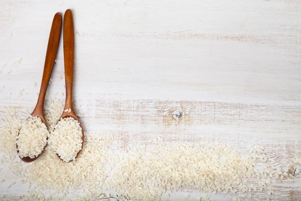 Arroz crudo y dos cucharas — Foto de Stock