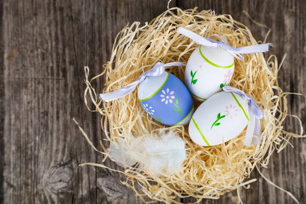Osterstillleben mit Nest, Federn und Eiern. — Stockfoto