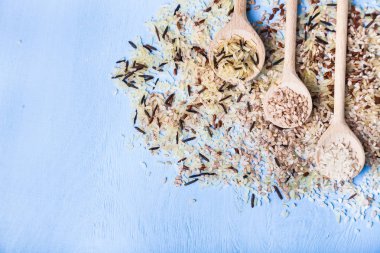 Üç kaşık pirinç eski bir ahşap zemin üzerinde farklı dersten. Sağlıklı bir diyet için madde.