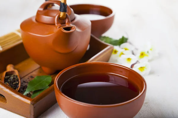 Ceramic teapot, tea leaves and sakura