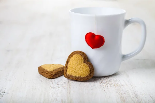 Tea in a mug with a heart and cookies — Stock Photo, Image