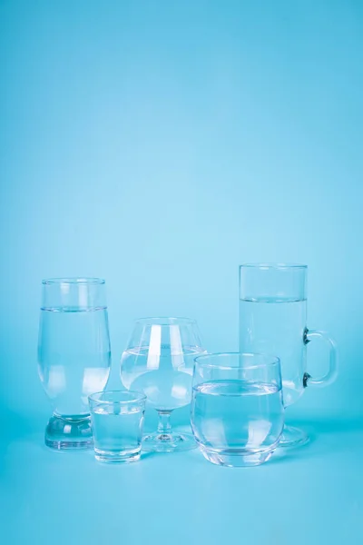 Transparent water in different glasses — Stock Photo, Image