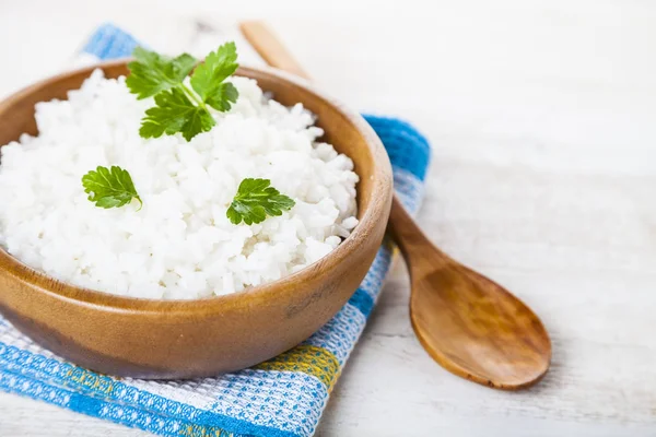 Kokt ris i en träskål och sked — Stockfoto
