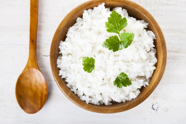 Arroz hervido en un tazón de madera y cuchara — Foto de Stock