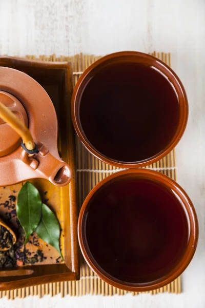 Bule de cerâmica e folhas de chá — Fotografia de Stock