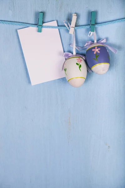 Huevos de Pascua y papel en una cuerda —  Fotos de Stock