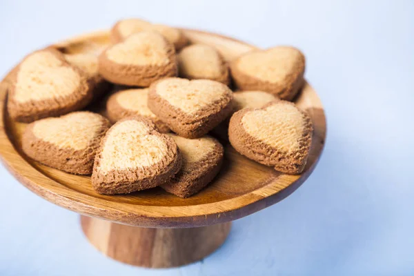 Cookies em forma de coração em um prato de madeira — Fotografia de Stock