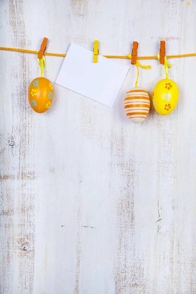 Uova di Pasqua e carta su una corda — Foto Stock