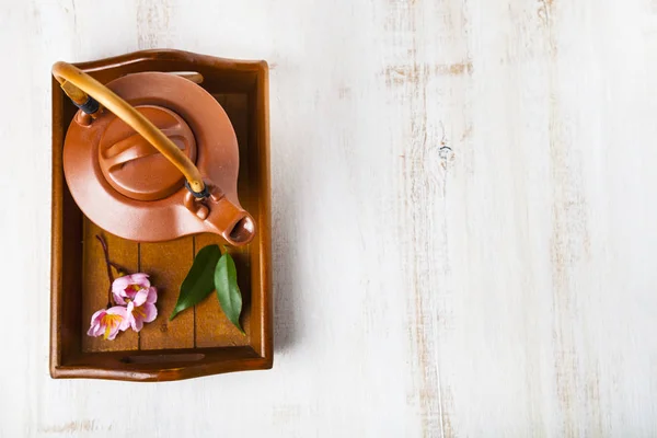 Керамический чайник, листья чая и сакура — стоковое фото