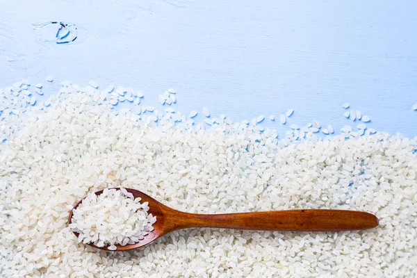 Surowy ryż i łyżka — Zdjęcie stockowe