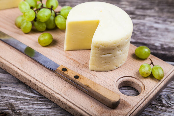 Cheese,  knife and grapes 