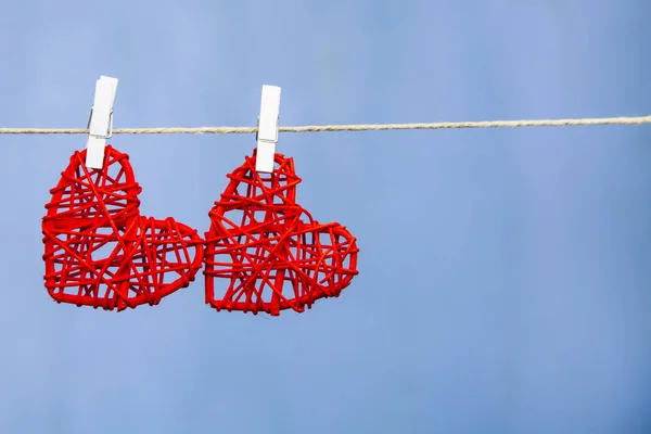 Dois corações vermelhos pendurados em uma corda — Fotografia de Stock