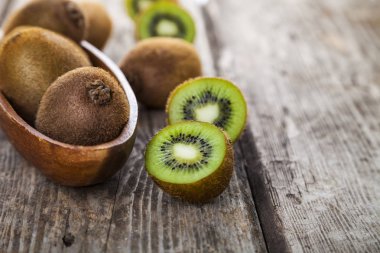 Ahşap bir tabak içinde olgunlaşmış kivi 