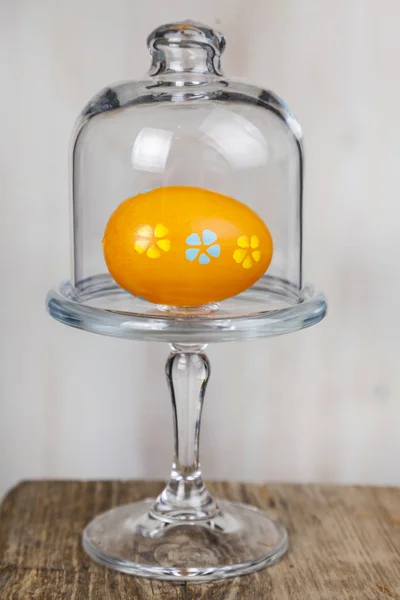 Huevo de Pascua en un plato de vidrio transparente . — Foto de Stock