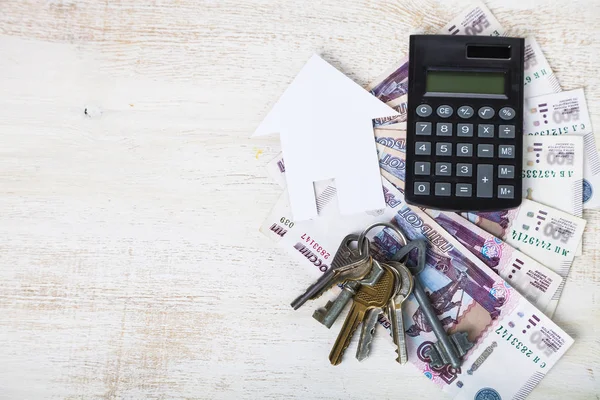 Casa de cartón, llaves, calculadora y dinero — Foto de Stock