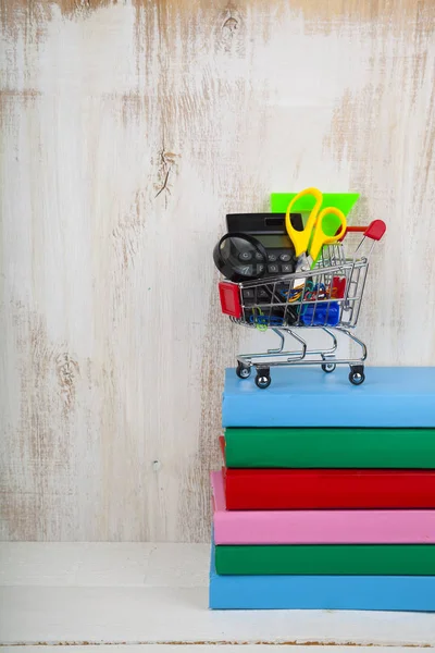 Schulsachen im Einkaufswagen und Bücher — Stockfoto