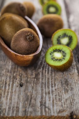 Ahşap bir tabak içinde olgunlaşmış kivi 