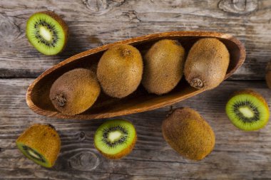 Ahşap bir tabak içinde olgunlaşmış kivi 