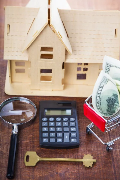 Money in a shopping cart and a house — Stock Photo, Image