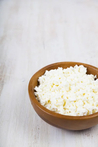 Cottage cheese in a wooden bowl — Stock Photo, Image