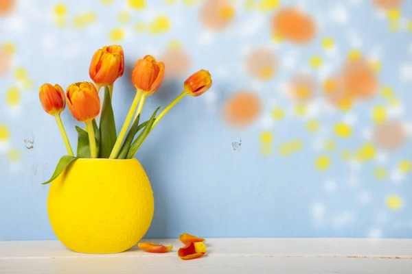 Tulipanes en un jarrón amarillo — Foto de Stock