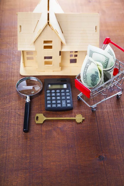 Money in a shop trolley and a house — Stock Photo, Image